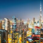 Aerial panoramic view of a big futuristic city by night. Business bay, Dubai, United Arab Emirates. Nighttime skyline.